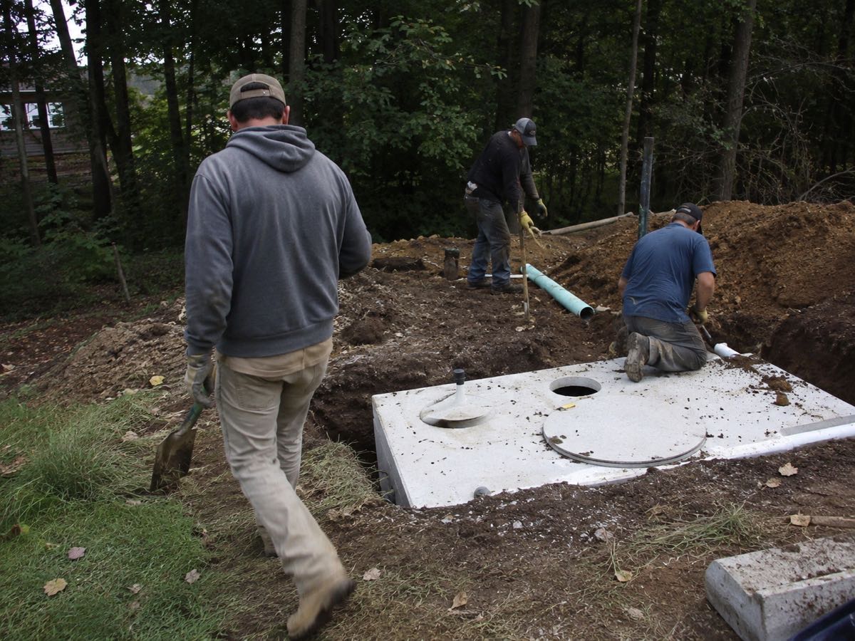 Setting a concrete septic tank with risers